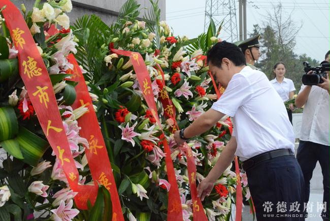 市委书记王群为摆放好的花篮整理好挽联市委副书记,市长周德睿主持